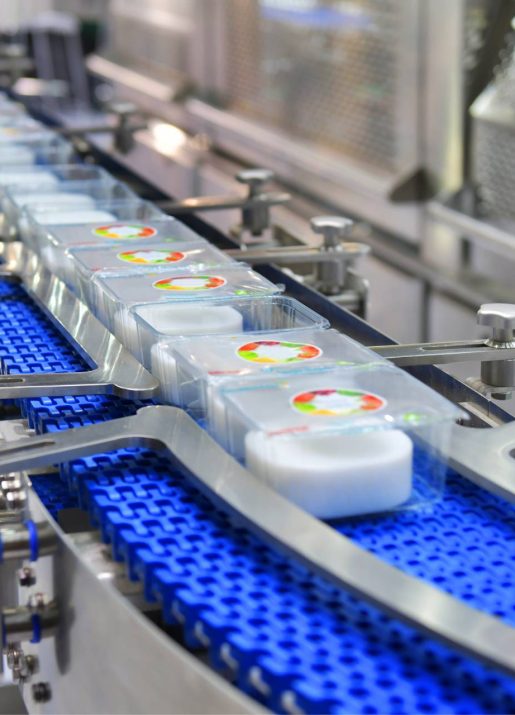 A factory conveyor belt with automated integration and blue cups needing repairs.