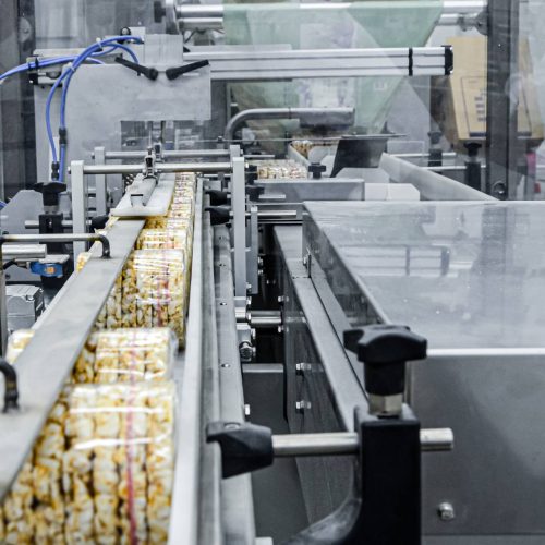 A machine is making food in a factory utilizing factory automation.